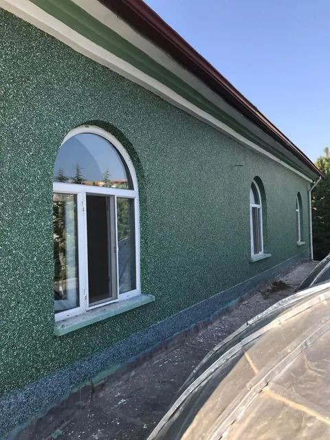 Kemerli pencereli binada yeşil benekli dış cephe kaplaması