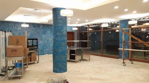 Kurulum aşamasındaki salonda mavi desenli pamuk sıva kolonlar