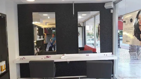 Kuaför salonunda aynaların arkasında siyah pamuk sıva duvar
