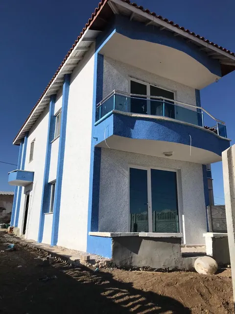 Beyaz cephe ve mavi bant detaylı iki katlı ev
